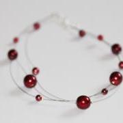 Floating multi strand illusion necklace in red glass pearls